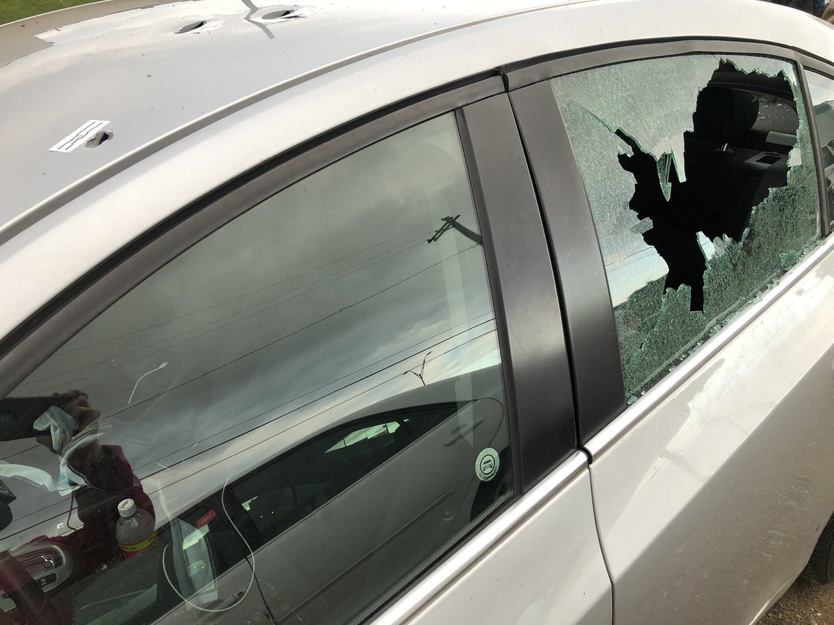 Cars parked in a lot across from the AirBnB have bullet holes and shattered windows