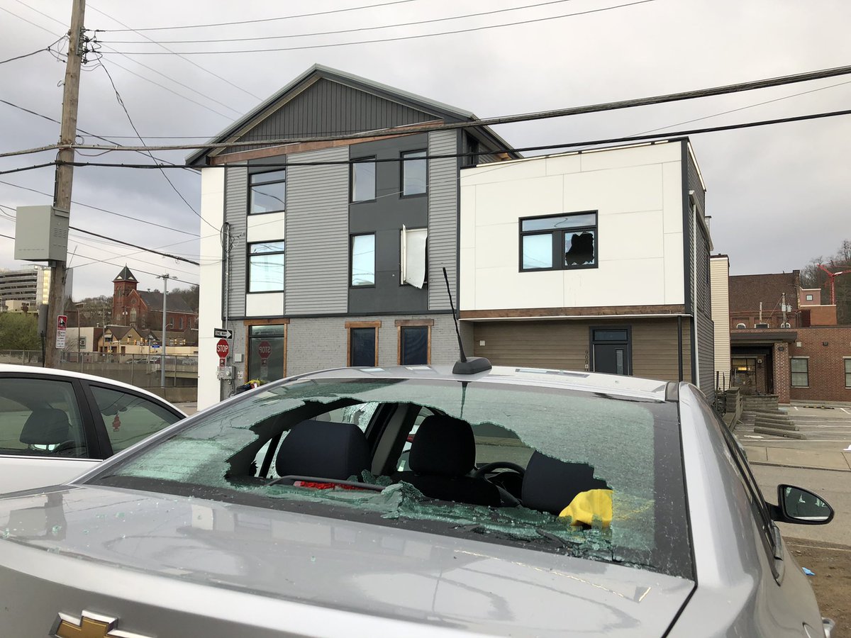 Cars parked in a lot across from the AirBnB have bullet holes and shattered windows