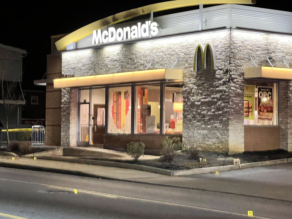 Officers have secured the scene, which spans the block around the restaurant, with crime tape. Within that space you can see dozens of evidence markers. The most visible and jarring piece of evidence being the shattered glass under the @McDonalds sign